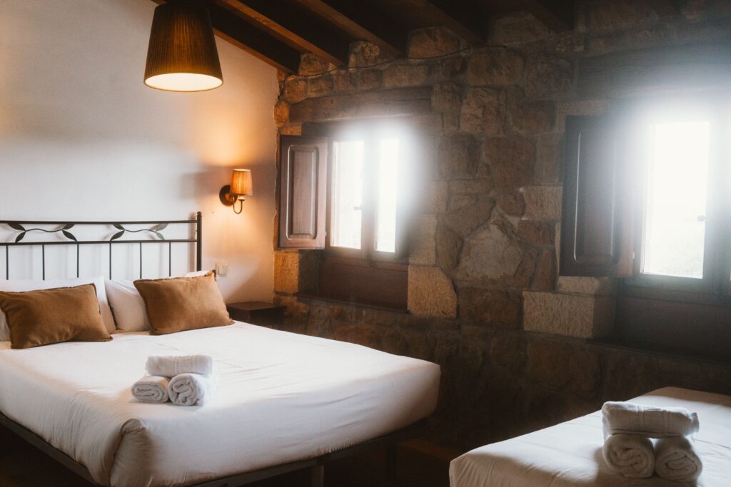 Camas y ventanas de una habitación de una casa rural de Fuente de Güelo