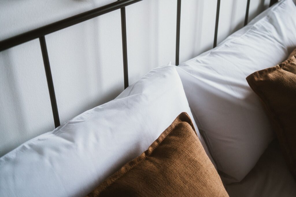 Detalle del cabecero de la cama y almohadas en una casa rural de Fuente de Güelo