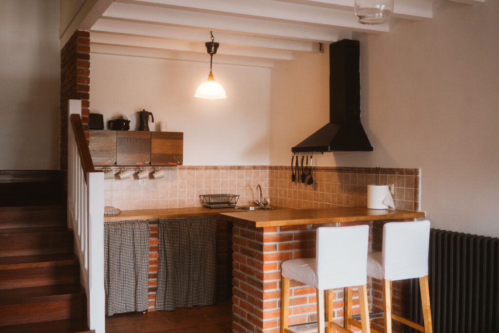 Vista de cocina completa y escalera en una casa rural de Fuente de Güelo
