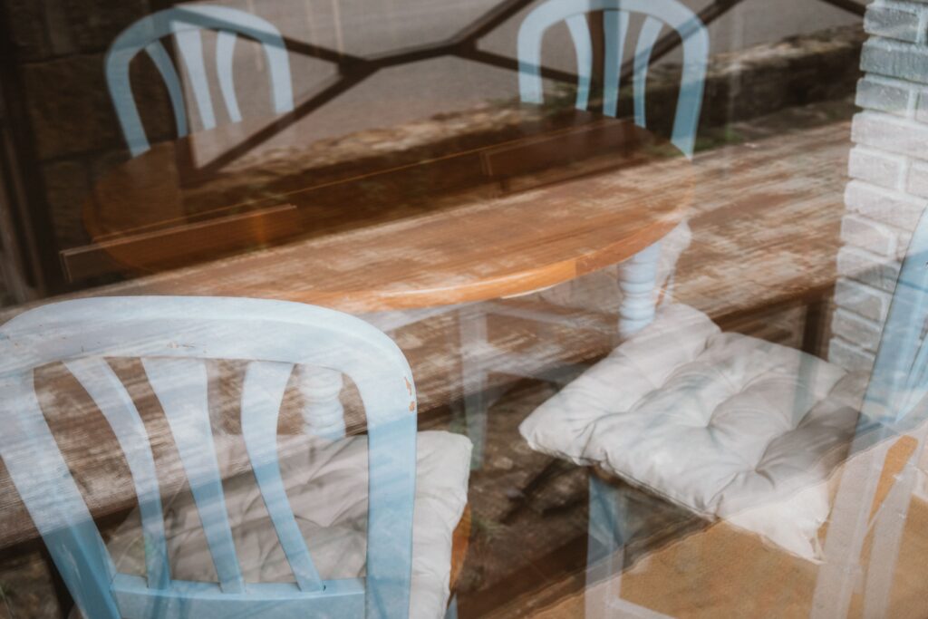 Reflejo de detalle de la mesa de comedor y sillas de una casa rural de Fuente de Güelo